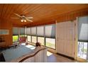Bright sunroom featuring wood paneling, large windows with blinds, and tiled flooring at 509 N Scenic Hwy, Frostproof, FL 33843