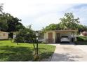 Inviting single-story home with a covered carport, complemented by a tidy lawn and mature trees at 7 Lamplight Ln, Winter Haven, FL 33884
