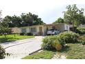 A quaint single-story house featuring a covered carport and a well-kept front yard with shrubs at 7 Lamplight Ln, Winter Haven, FL 33884