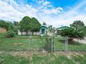Landscaped front yard with mature trees and chain link fence surrounding property at 715 S Seminole Ave, Fort Meade, FL 33841