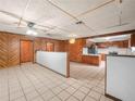 Open-concept kitchen with white tile floors, and wood paneled walls at 715 S Seminole Ave, Fort Meade, FL 33841