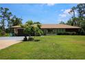 Lovely single-story home with manicured lawn, lush landscaping, and welcoming curb appeal at 7591 Limonia Dr, Indian Lake Estates, FL 33855