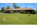 Well-maintained home with a tile roof, verdant lawn, and attractive landscaping at 7591 Limonia Dr, Indian Lake Estates, FL 33855