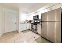 Well-lit kitchen with stainless steel appliances, white cabinetry, and tiled flooring at 821 Orchid Springs Dr # 821, Winter Haven, FL 33884