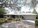 Charming home featuring mature landscaping, an attached garage, and a well-maintained front yard at 882 Redwood Way, Lake Wales, FL 33898