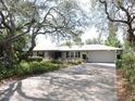Single-story home with a well-manicured front yard, beautiful landscaping, and long driveway at 882 Redwood Way, Lake Wales, FL 33898