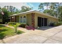Well-maintained single-story home with an attached garage and sliding glass doors to the back, surrounded by green lawns at 9365 Lemon Dr, Lake Wales, FL 33898
