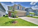 Inviting two-story home with a lush green lawn, spacious driveway, and beautiful landscaping at 1417 Leamington Ln, Winter Haven, FL 33884