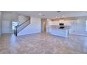 Open-concept living space featuring tile flooring and a kitchen with white cabinets and granite countertops at 1417 Leamington Ln, Winter Haven, FL 33884