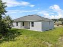 A single-story home, showcasing white stucco exterior, well-maintained lawn, and covered porch at 4502 Fairway Oaks Dr, Mulberry, FL 33860