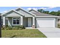 Well-maintained single-story home with neutral exterior, manicured lawn, and convenient two-car garage at 4537 Fairway Oaks Dr, Mulberry, FL 33860