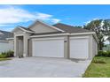 Single-story home with a two-car garage, landscaped yard, located in a serene setting at 4541 Fairway Oaks Dr, Mulberry, FL 33860