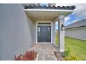 Inviting front entrance with a covered porch and elegant brick pathway at 4646 Grandview Glen Dr, Auburndale, FL 33823
