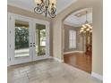 Inviting foyer with tile flooring, chandelier, and an arched entrance to an adjacent dining or living space at 6487 Ashley Dr, Lakeland, FL 33813