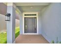 Inviting front entrance featuring a gray front door with sidelights and a covered porch at 1484 Leamington Ln, Winter Haven, FL 33884