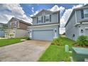 Two-story home with a two-car garage and a concrete driveway, surrounded by green lawns at 1484 Leamington Ln, Winter Haven, FL 33884
