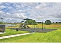 Community playground with slide, swings and benches next to a lake at 1484 Leamington Ln, Winter Haven, FL 33884