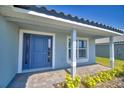 Welcoming front entry with a blue door, sidelight window, and brick paver porch at 4670 Grandview Glen Dr, Auburndale, FL 33823