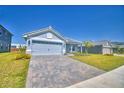 Charming single-story home featuring a paver driveway, a two-car garage, and well-maintained landscaping at 4670 Grandview Glen Dr, Auburndale, FL 33823