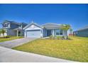 Charming single-story home with a well-manicured lawn, brick driveway, and a two-car garage at 4670 Grandview Glen Dr, Auburndale, FL 33823