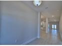 Bright hallway featuring tile floors and a view into the kitchen and dining area at 4938 Vue Delac Pass, Auburndale, FL 33823
