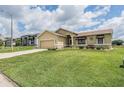 Exterior view of the home with an expansive green lawn, showcasing its curb appeal in the neighborhood at 5879 Swallow Dr, Lakeland, FL 33809