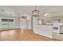 Open-concept living area with wood floors and a view of kitchen, perfect for modern living at 5879 Swallow Dr, Lakeland, FL 33809