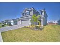Charming two-story home with a three-car garage and a well-manicured lawn at 4676 Grandview Glen Dr, Auburndale, FL 33823