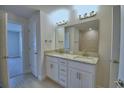 Bathroom featuring double sinks with granite counters, a large mirror and tile flooring at 4687 Grandview Glen Dr, Auburndale, FL 33823