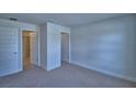 Spacious bedroom with neutral carpet, white walls, and paneled doors to two large closets at 4687 Grandview Glen Dr, Auburndale, FL 33823