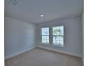Bright bedroom featuring neutral carpet, white walls and trim, and two large double-hung windows at 4687 Grandview Glen Dr, Auburndale, FL 33823