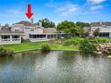 Beautiful view of the home's back exterior with lake, landscaping, and screened in porch at 1144 Waterfall Ln # 26, Lakeland, FL 33803