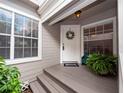 Inviting front entrance with a white door, a wreath, and potted plants at 1144 Waterfall Ln # 26, Lakeland, FL 33803
