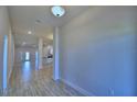 Bright and open hallway with wood-look tile flooring, recessed lighting, and access to the kitchen and other rooms at 5120 Villa Crest Way, Auburndale, FL 33823