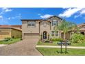 Charming home boasting a well-manicured lawn, brick driveway, and a symmetrical, inviting facade at 4184 Prima Lago Cir, Lakeland, FL 33810