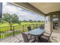 Enjoy the serene golf course view from this balcony, featuring a table and comfortable seating at 7330 Reflections Lake Dr, Lakeland, FL 33813