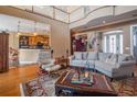 Spacious living room with hardwood floors, a large sofa, and a view of the kitchen at 7330 Reflections Lake Dr, Lakeland, FL 33813