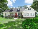 Charming single Gathering home with lush landscaping, three dormers, and a bright red front door at 1096 Drew St, Lakeland, FL 33810