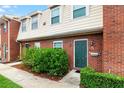 Brick townhouse exterior with green door and landscaping at 1920 E Edgewood Dr # G5, Lakeland, FL 33803