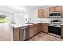 Modern kitchen with stainless steel appliances and light wood cabinets at 631 Bentley North Dr, Auburndale, FL 33823