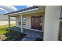 Inviting covered porch with stone pathway and manicured landscaping leading to the home's entrance at 4544 Grand View Glen Dr, Auburndale, FL 33823