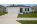 Two-car garage with gray house and landscaping at 296 Spirit Landings Cir, Winter Haven, FL 33880