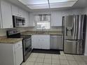 Well-lit kitchen featuring stainless steel appliances, granite countertops, and white cabinetry at 462 Cameo Dr # 462, Lakeland, FL 33803