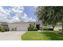 Inviting home exterior with a well-kept lawn, mature landscaping, and a two-car garage at 6769 Hampshire Blvd, Lakeland, FL 33813