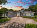 Gray two-story house with a three-car garage and manicured landscaping at 800 Osprey Landing Dr, Lakeland, FL 33813