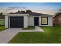Charming one-story home with a black garage door and modern exterior paint at 1918 Dr Martin L King Jr Way, Haines City, FL 33844