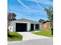 Charming single story home with a black garage door, manicured lawn, and bright sky at 1918 Dr Martin L King Jr Way, Haines City, FL 33844