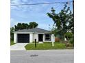Charming single-story home with a well-manicured lawn, black garage door, and inviting curb appeal at 1918 Dr Martin L King Jr Way, Haines City, FL 33844