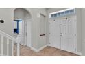 Inviting entryway with tile flooring, coat closet, and transom window above the front door at 6857 Eagle Ridge Loop, Lakeland, FL 33813