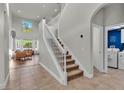Open foyer with staircase, tile flooring, and view to a living room and laundry area at 6857 Eagle Ridge Loop, Lakeland, FL 33813
